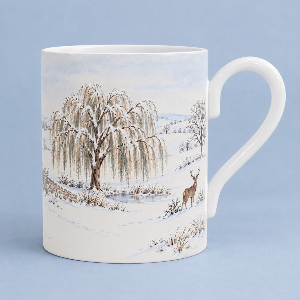 Winter wildlife mug with stag beside a snow-covered willow tree in a snowy British countryside landscape