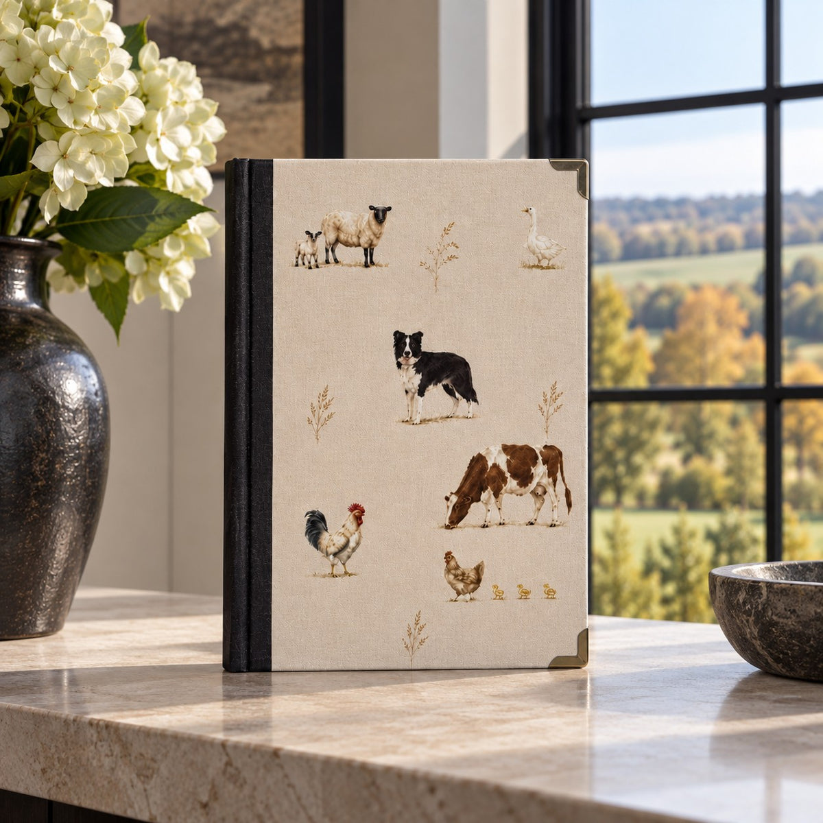 The Farmyard Journal from the Aminelle & Willow Country Edit featuring illustrated sheep, Border Collie, cow, goose and chickens on a satin hardback cover